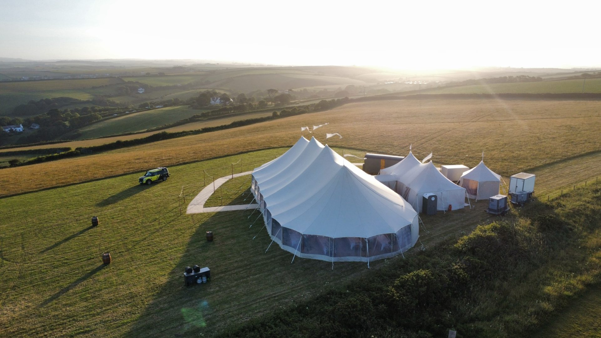 Aerial view of a marquee in a field at sunset
