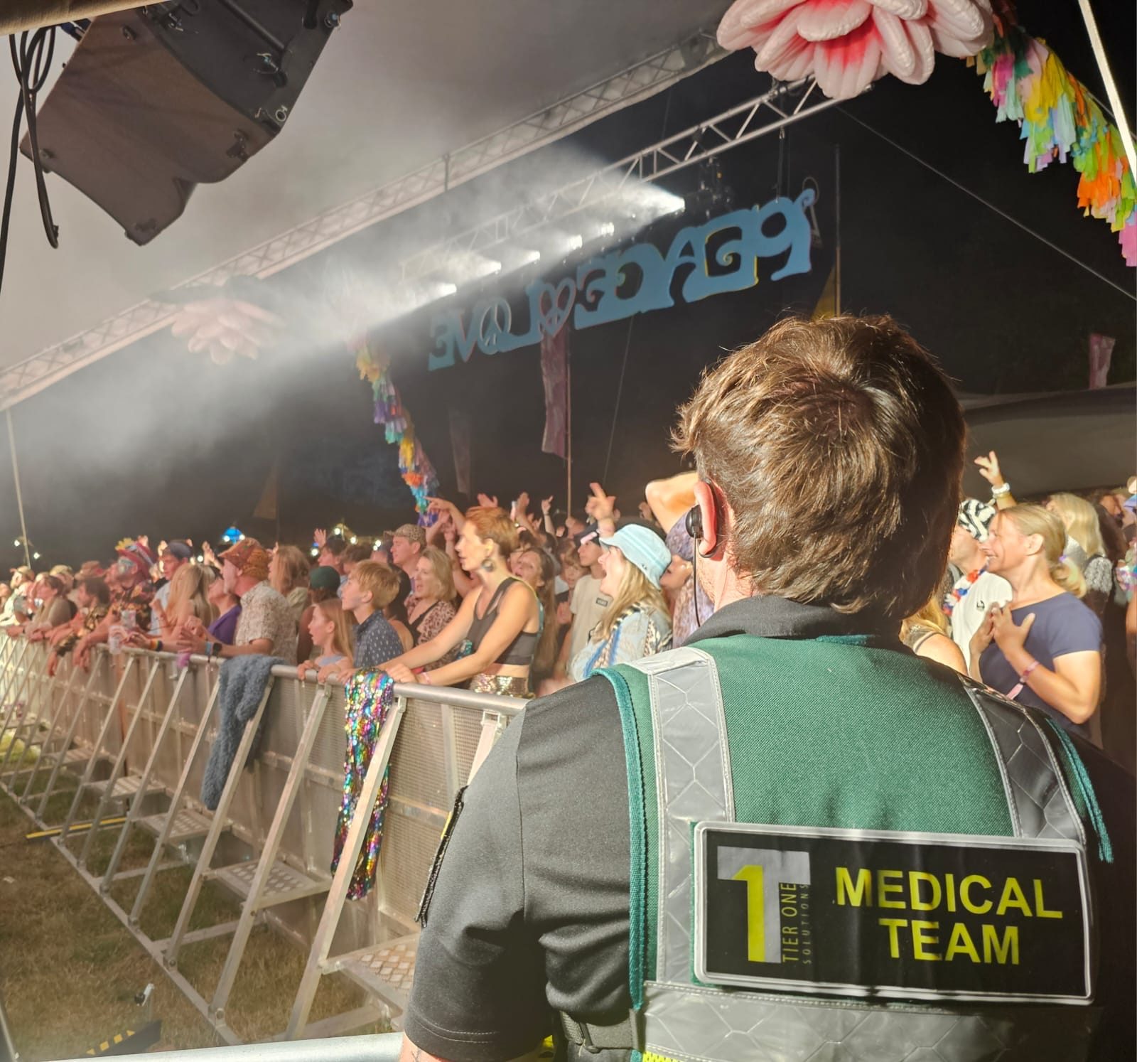 Medic watching the crowd from the front of stage barrier
